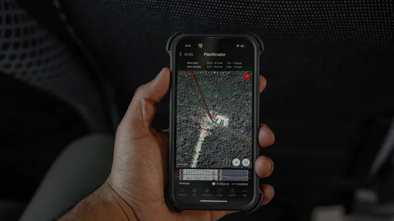 A hand holding a smartphone that displays a map